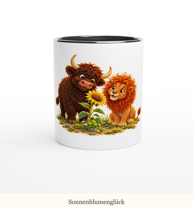 May include: A white ceramic mug with a black interior rim featuring a colorful illustration of a brown highland cow and a golden lion cub standing together in a grassy field with a single bright yellow sunflower between them.