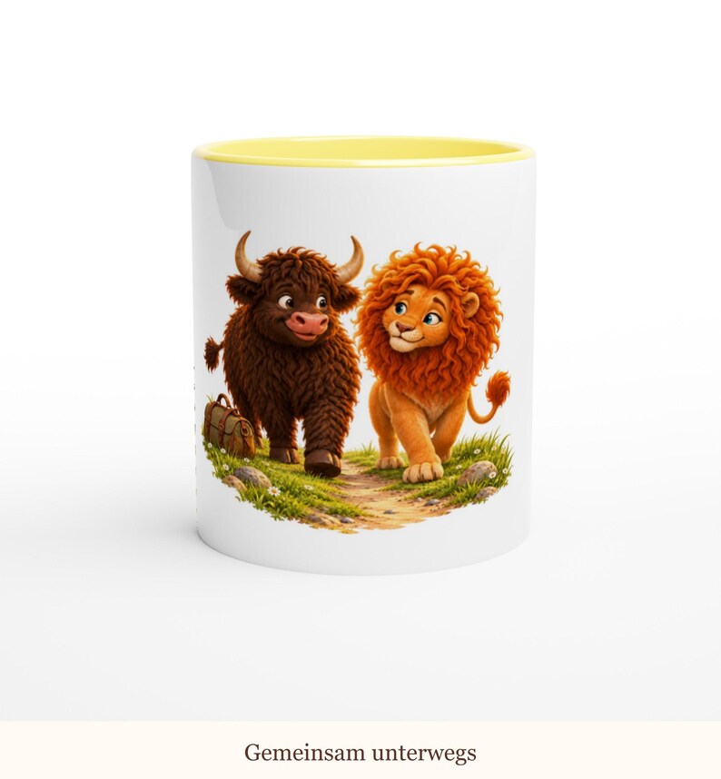 May include: A white ceramic mug with a yellow interior rim featuring a cartoon illustration of a brown highland cow and an orange lion walking together on a grassy path. The text "Gemeinsam unterwegs" is printed at the bottom of the mug.