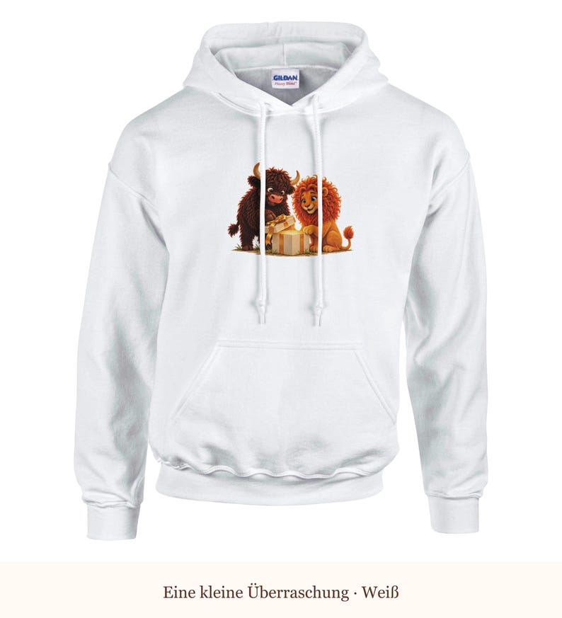 K&ouml;nnte beinhalten: Ein wei&szlig;er Kapuzenpullover mit einem Grafikdruck, der ein braunes Hochlandrind und einen L&ouml;wen zeigt, die gemeinsam ein Geschenk &ouml;ffnen. Der Hoodie hat lange &Auml;rmel, eine K&auml;ngurutasche und wei&szlig;e Kordelz&uuml;ge am Halsausschnitt.