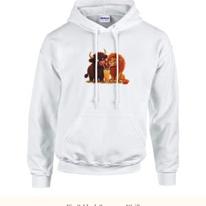 K&ouml;nnte beinhalten: Ein wei&szlig;er Kapuzenpullover mit einem Grafikdruck, der ein braunes Hochlandrind und einen goldenen L&ouml;wen zeigt, die gemeinsam ein Glas Orangensaft mit zwei Strohhalmen teilen. Der Hoodie verf&uuml;gt &uuml;ber lange &Auml;rmel, eine K&auml;ngurutasche und eine Kapuze.
