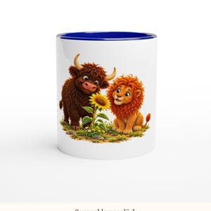 May include: A white ceramic mug with a dark blue interior and rim. The exterior features a colorful illustration of a brown Highland cow and an orange lion sitting together in a grassy field, looking at a single yellow sunflower.