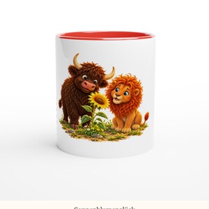 May include: A white ceramic mug with a red interior rim featuring a graphic illustration of a brown highland cow and an orange lion sitting together in a grassy field looking at a yellow sunflower with the text Sonnenblumengl&uuml;ck.