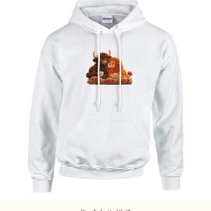 K&ouml;nnte beinhalten: Ein wei&szlig;er Kapuzenpullover mit einem Grafikdruck, der ein braunes Hochlandrind und einen orangefarbenen L&ouml;wen zeigt, die zusammen auf einer rot karierten Decke sitzen und jeweils eine kleine wei&szlig;e Tasse halten. Mit Kordelzug und Tasche.