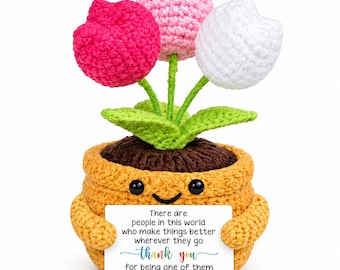 May include: A crocheted potted plant featuring three tulips in red, pink, and white with green leaves. The mustard yellow pot has a smiling face and holds a white card with the text: There are people in this world who make things better wherever they go thank you for being one of them.