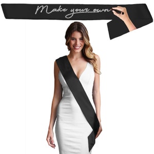 May include: Black satin sash with the text "Make your own" written in silver glitter. The sash is worn diagonally across the chest.