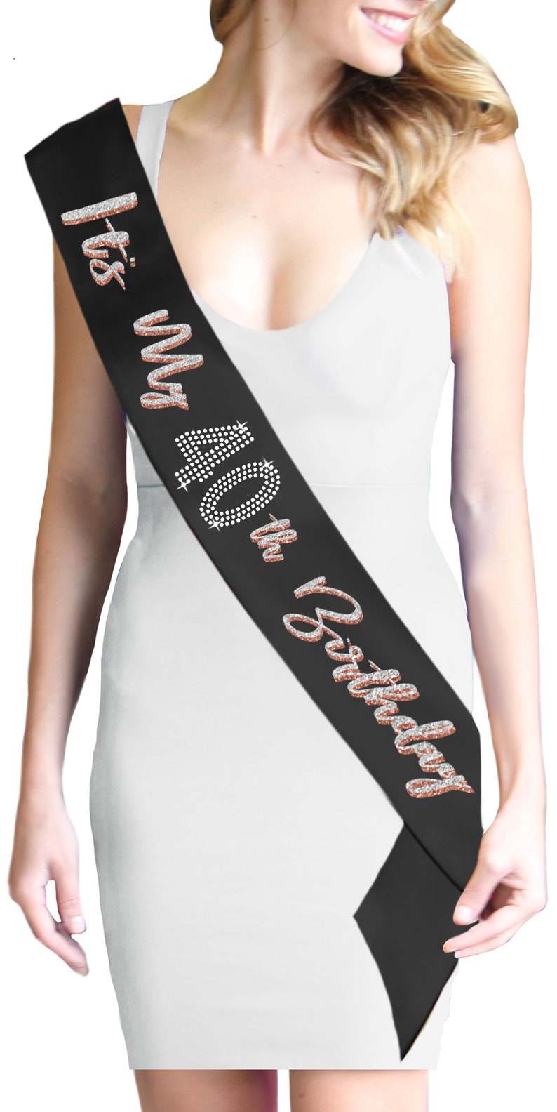 May include: Black satin sash with the text "It's My 40th Birthday" in rose gold glitter and rhinestone accents. The sash is worn diagonally across the body, a celebratory accessory for a milestone birthday.