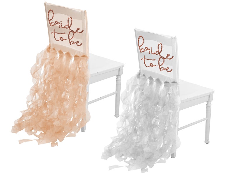 Rose Gold Organza chair cover that says Bride to Be in rose gold glitter lettering. White Organza chair cover that says Bride to Be in rose gold glitter lettering.