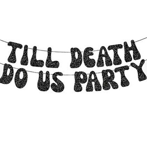 May include: A black glittery banner featuring the text TILL DEATH DO US PARTY arranged in two rows. The letters have a wavy, bold font style and are strung together on thin horizontal lines, creating a decorative hanging sign for events.
