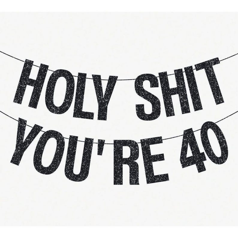 May include: A banner with the text "HOLY SHIT YOU'RE 40" in black glitter letters, strung on a thin black string, against a white background. The banner is designed for a 40th birthday celebration.