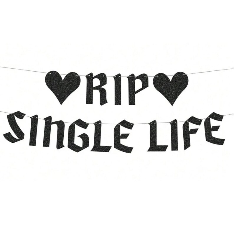 May include: A black glittery banner featuring two heart shapes and the text RIP SINGLE LIFE in a gothic-style font. The letters and hearts are strung together on a thin silver string, creating a two-line decorative party garland.