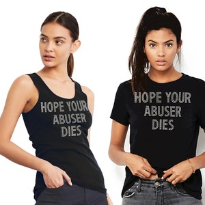 May include: A black sleeveless tank top and a black short-sleeved t-shirt, both featuring the text "HOPE YOUR ABUSER DIES" written in silver-toned rhinestones across the chest area. The garments are plain black with a simple crew neckline design.