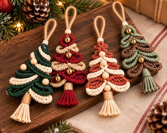 May include: Four macrame Christmas tree ornaments made of twisted cotton cord in dark green, red, rust, and sage green. Each tree features alternating cream-colored cord layers, small wooden beads, gold jingle bells, and a bottom tassel.