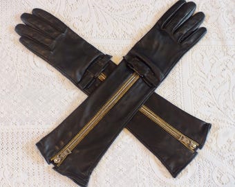 PRADA. Guantes negros de piel de cordero hasta el codo. Presentan cremallera bicolor y lazos.