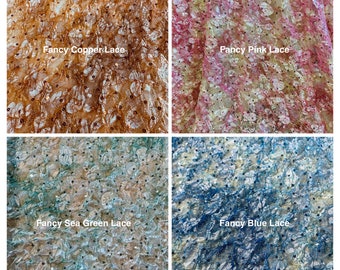 May include: Four fabric swatches: Fancy Copper Lace, Fancy Pink Lace, Fancy Sea Green Lace, and Fancy Blue Lace. Each swatch features a delicate lace pattern with small, dark embellishments. The copper and pink laces have warmer tones, while the sea green and blue laces are cooler.
