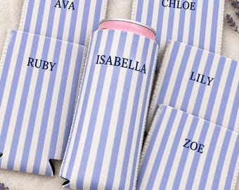 Könnte beinhalten: Fünf hellblau-weiß gestreifte Dosenkühler aus Neopren, jeweils mit einem individuellen Namen in dunkelblauen Großbuchstaben bedruckt: Ava, Chloe, Ruby, Isabella und Lily. Ein Kühler ist um eine Getränkedose gewickelt.