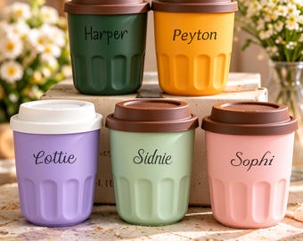 May include: Five reusable cups with lids, each featuring a unique color and a personalized name. The cups are dark green with Harper, yellow with Peyton, lavender with Lottie, light green with Sidnie, and light pink with Sophi printed on them.