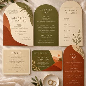 Puede incluir: Un conjunto de papelería de boda con tarjetas rectangulares y en forma de arco en tonos crema, verde oliva y terracota. Los diseños incluyen texto impreso, ilustraciones botánicas y gráficos de paisajes. Dos anillos de oro descansan en un pequeño plato de cerámica.