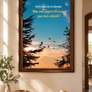 Puede incluir: Un cuadro decorativo con una impresión de un atardecer, siluetas de pinos y aves volando. El texto dice: Refranes de la abuela, Mas vale pajaro en mano, que cien volando. El marco es de madera de color marrón oscuro y forma rectangular.