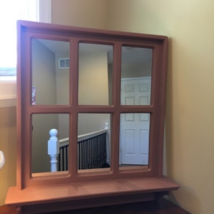 Painted Apache Clay,
measures (plus or minus) 25.5" W x (plus or minus) 28 3/8" H.  Has a 4" shelf with 3 wood shaker pegs.