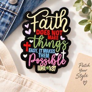 Puede incluir: Un parche bordado negro con el texto Faith DOES NOT MAKE things EASY, IT MAKES THEM Possible LUKE 1:37 en hilo amarillo, rojo, verde, azul y rosa, decorado con pequeños corazones bordados y dos pequeñas cruces.
