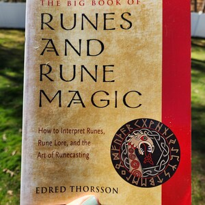 Op de afbeelding: Het Grote Boek van Runen en Runenmagie door Edred Thorsson. De omslag van het boek heeft een rood en gouden ontwerp met een zwart-witte illustratie van een drakenkop omringd door runen.