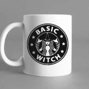 Könnte beinhalten: Weiße Keramiktasse mit einer schwarz-weißen Grafik. Die Grafik ist eine Parodie auf ein beliebtes Café-Logo, das eine Hexe mit spitzem Hut und die Worte "BASIC WITCH" in einem kreisförmigen Design zeigt. Die Tasse hat einen gebogenen Henkel.