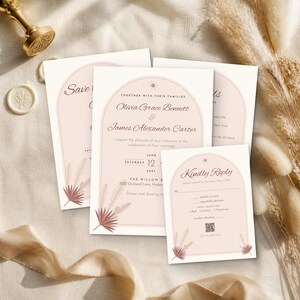 May include: A wedding invitation suite featuring a pale pink arch design with a sun icon, dried palm leaf illustrations, and dark brown text. The cards include names Olivia Grace Bennett and James Alexander Carter, date June 12, 2027, and a QR code on the reply card.