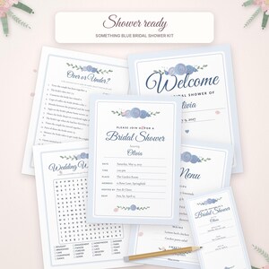 May include: A bridal shower stationery kit featuring blue floral accents and dark blue text. The set includes a welcome sign, invitation, menu, wedding word search, and an Over or Under game, all displayed on a light pink background with a wooden pencil.