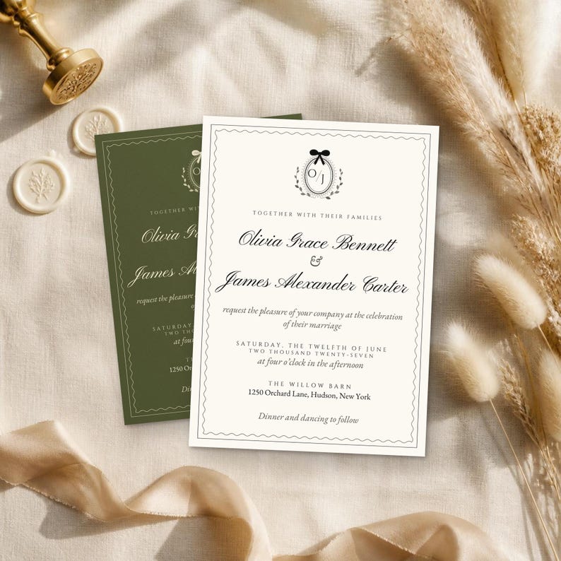 K&ouml;nnte beinhalten: Eine cremefarbene Hochzeitseinladungskarte mit schwarzem Text und einem kleinen Schleifensymbol &uuml;ber den Initialen O/J, mit einem gewellten Rand. Eine zweite, identische Einladung in Olivgr&uuml;n liegt unter der cremefarbenen Karte.