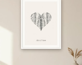 May include: A framed wall art print featuring a black fingerprint heart graphic centred on a cream background. Below the heart, the text reads Alex & Sam in a serif font. The bottom of the image includes the text Your fingerprints, one heart - digital download.