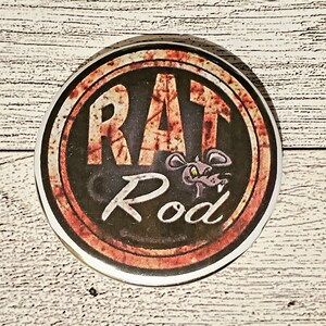 May include: A round, rusty-red and black button with the words "Rat Rod" and a cartoon rat with yellow eyes.