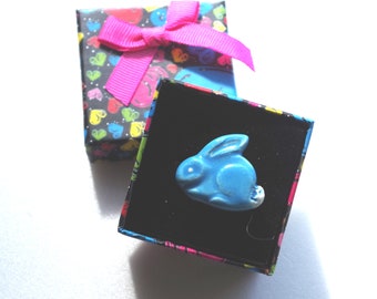 Jolie bague cabochon petit lapin bleu, céramique artisanale sur une monture réglable.
