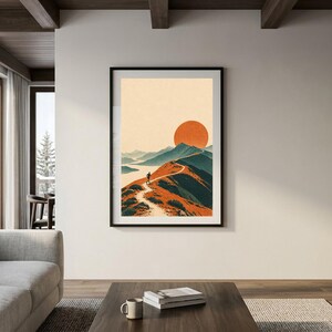 Peut inclure: Une impression d'art mural verticale encadr&eacute;e repr&eacute;sentant une illustration de paysage stylis&eacute;e avec un sentier de montagne sinueux, un randonneur solitaire, des cha&icirc;nes de montagnes bleu-vert et un grand soleil orange.