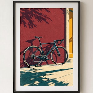 Op de afbeelding: Een donkergekleurde racefiets met dunne banden en een racestuur staat geparkeerd tegen een getextureerde dieprode muur naast een geel deurkozijn, wat een duidelijke schaduw werpt op de grond en de muur in fel zonlicht.