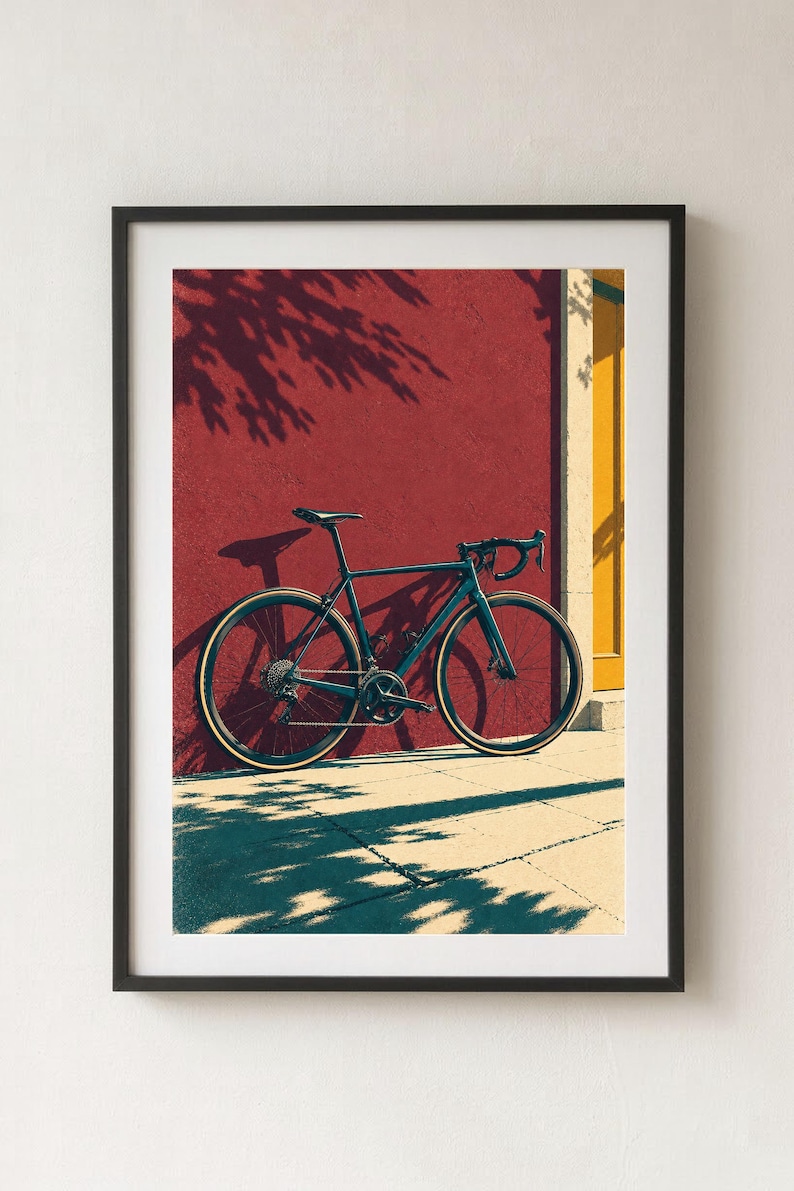 Op de afbeelding: Een donkergekleurde racefiets met dunne banden en een racestuur staat geparkeerd tegen een getextureerde dieprode muur naast een geel deurkozijn, wat een duidelijke schaduw werpt op de grond en de muur in fel zonlicht.