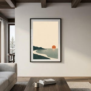 Puede incluir: Una l&aacute;mina de arte mural vertical enmarcada que muestra un paisaje costero minimalista con un cielo beige, una costa verde oscuro, una playa de arena clara y un sol naranja s&oacute;lido situado sobre el horizonte del mar azul.