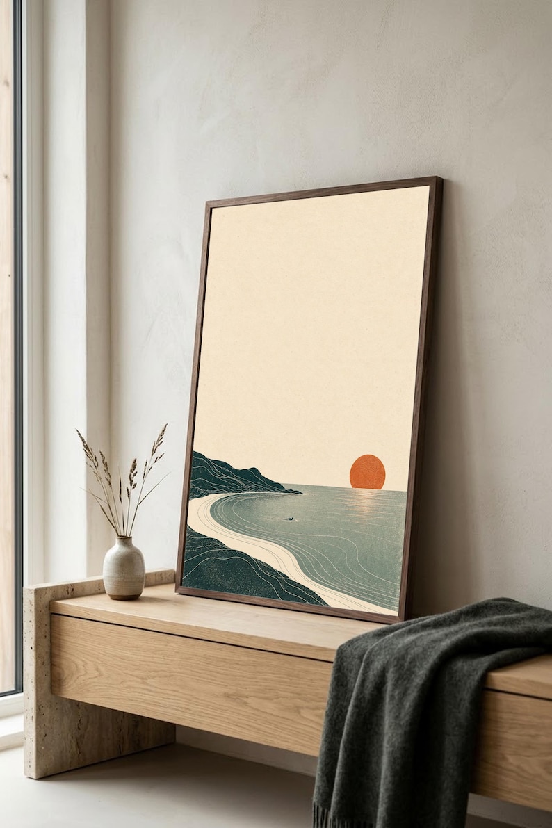 Puede incluir: Una l&aacute;mina de arte vertical enmarcada que muestra un paisaje costero con una costa verde oscuro, una playa de arena y un mar en calma bajo un cielo color crema. Un c&iacute;rculo naranja s&oacute;lido representa el sol en el horizonte.