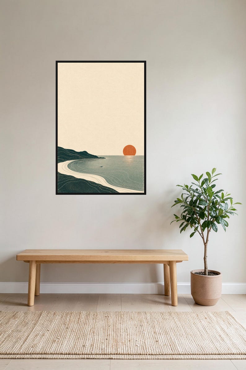Puede incluir: Una l&aacute;mina de arte mural vertical enmarcada que muestra un paisaje costero estilizado con una costa verde oscuro, una playa de arena beige claro, agua azul gris&aacute;cea tranquila y un sol naranja s&oacute;lido sobre un cielo color crema.