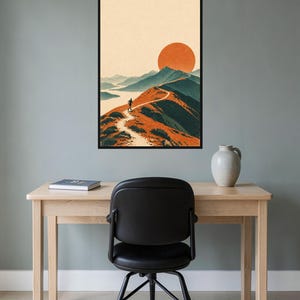 Peut inclure: Une impression d'art mural encadr&eacute;e repr&eacute;sentant une illustration de paysage avec une personne courant sur un sentier de cr&ecirc;te montagneuse. La sc&egrave;ne montre un grand soleil orange se couchant derri&egrave;re des sommets bleut&eacute;s et un sentier sinueux.