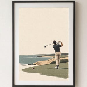 Puede incluir: Una lámina artística enmarcada que muestra a un golfista con camisa oscura y pantalones beige balanceando un palo de golf en un tee verde con vistas a un paisaje costero con dunas de arena, agua azul y un cielo claro de fondo.