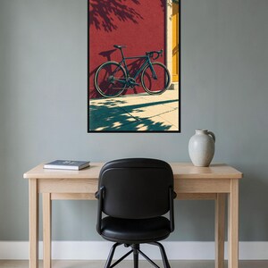 Op de afbeelding: Een ingelijste kunstprint met een donkerblauwe racefiets die tegen een felrode muur leunt. De sc&egrave;ne bevat een geel deurkozijn en duidelijke schaduwen die door de fiets en het gebladerte op de grond en de muur worden geworpen.