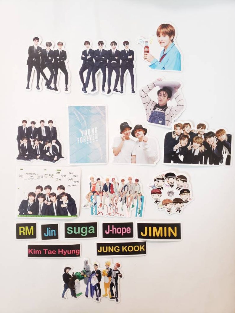 May include: A collection of stickers featuring a K-pop boy band. The stickers are printed on white paper and feature various images of the band members, including individual portraits, group photos, and cartoon illustrations. The stickers also include text such as "Young Forever", "RM", "Jin", "Suga", "J-Hope", "Jimin", "Kim Tae Hyung", and "Jung Kook".
