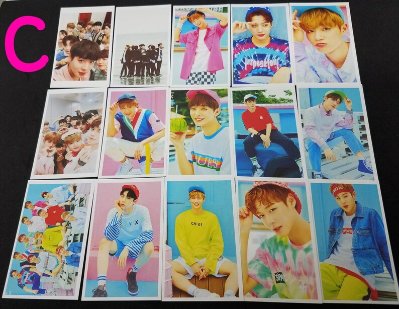 May include: A set of 12 photo cards featuring a K-pop boy band. The cards are printed on white cardstock and feature various images of the band members in different poses and outfits. The cards are all in a similar style, with a white border and a blue background. The band members are wearing colorful clothing and hats, and some are holding props such as watermelons and sunglasses. The cards are perfect for fans of the band or for collectors of K-pop memorabilia.