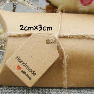 May include: A brown paper gift box with a twine bow and a small brown tag that says "Handmade with love". The tag is 2 cm by 3 cm.