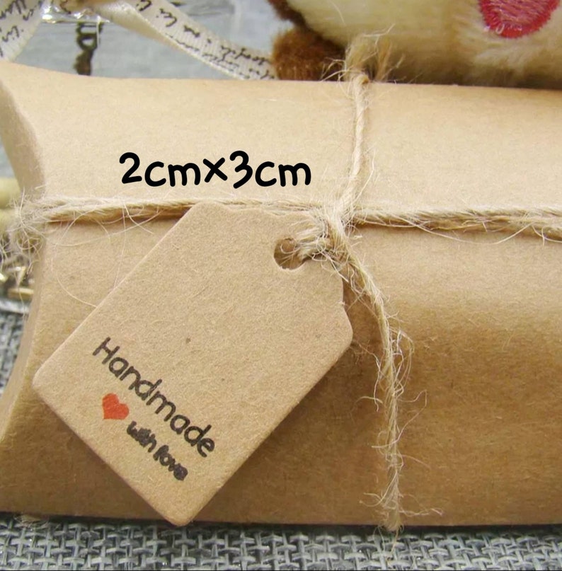 May include: A brown paper gift box with a twine bow and a small brown tag that says "Handmade with love". The tag is 2 cm by 3 cm.