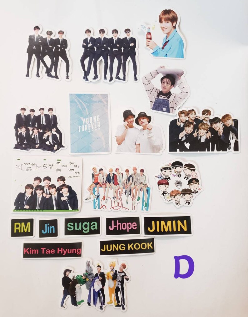 May include: A collection of stickers featuring the South Korean boy band BTS. The stickers feature various images of the band members, including individual portraits, group photos, and cartoon illustrations. The stickers are printed on white paper and have a glossy finish.