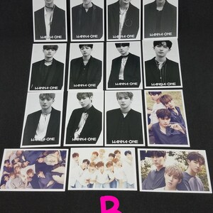 May include: A set of 12 black and white photo cards featuring a K-pop boy band. The cards feature individual band members and a group photo. The cards have the band's name "WANNA-ONE" printed on them.