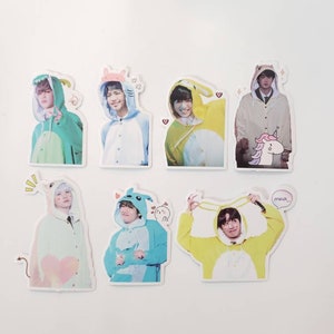 May include: Six colourful stickers featuring a person wearing a different animal costume on each sticker. The costumes include a green dinosaur, a white bear, a yellow bunny, a beige bear, a blue penguin, and a yellow bunny. Each sticker has a small cartoon animal on it and some have hearts or stars.