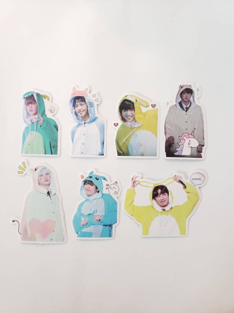 May include: Six colourful stickers featuring a person wearing a different animal costume on each sticker. The costumes include a green dinosaur, a white bear, a yellow bunny, a beige bear, a blue penguin, and a yellow bunny. Each sticker has a small cartoon animal on it and some have hearts or stars.