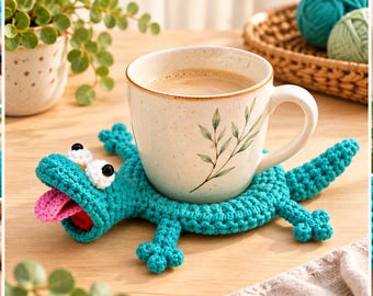 May include: A turquoise crochet lizard coaster with a white and brown speckled ceramic mug resting on its back. The lizard features a pink tongue, white eyes with black pupils, and four small legs. The image also shows various stages of the crochet process.